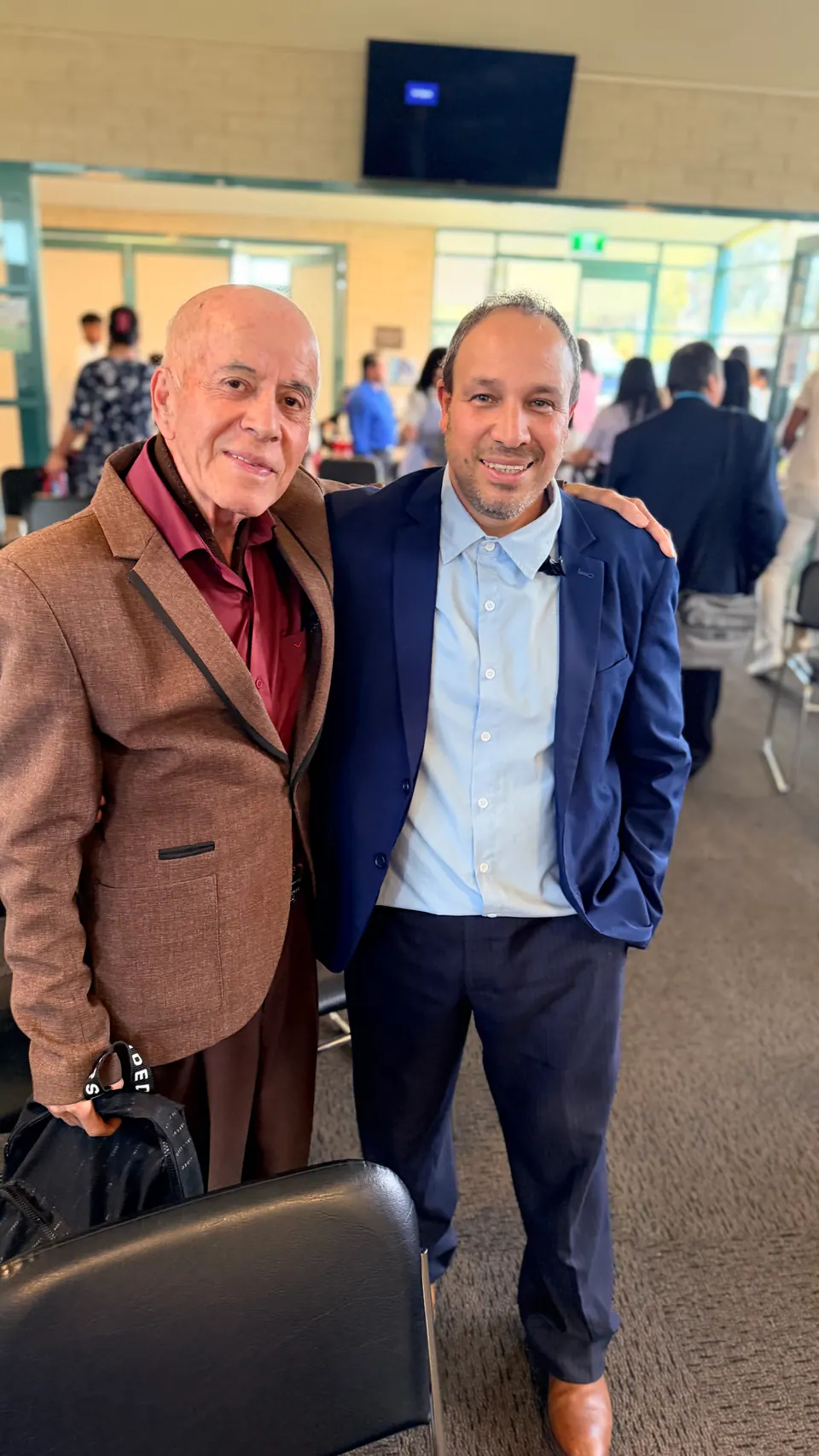 Dos hombres juntos y sonrientes en una reunión de la iglesia