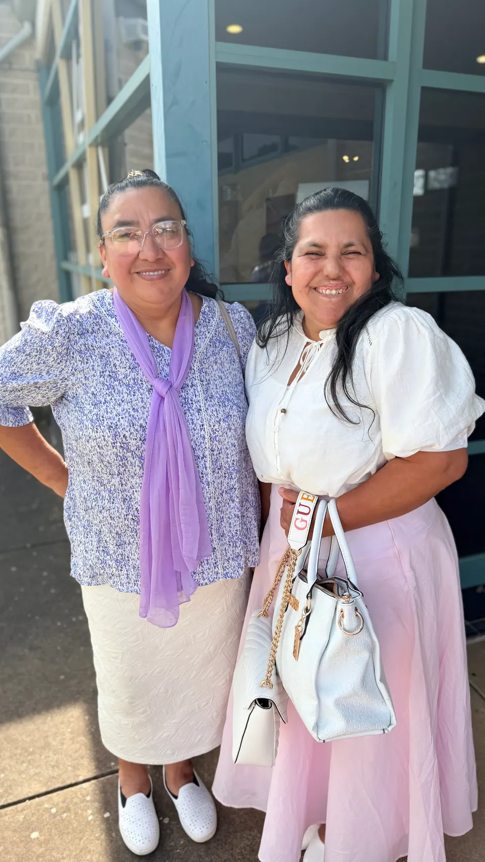 Dos mujeres sonriendo juntas en una reunión de la iglesia
