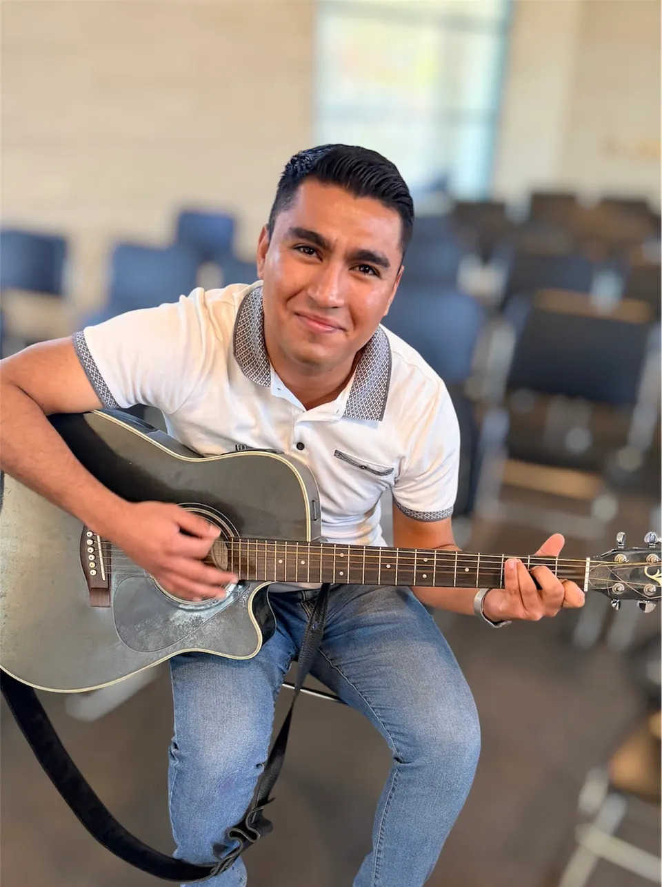 Un hombre tocando una guitarra acústica